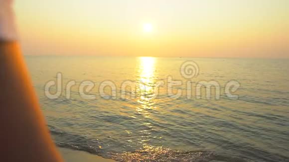 家庭海滩日落幸福的一家四口牵着手站在梦幻的沙滩上看着金色的海洋视频的预览图