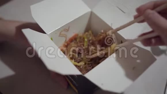 女性用筷子从盒子里拿出面条视频的预览图