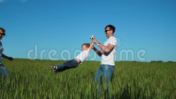 幸福的家庭父亲穿着白色T恤和牛仔裤围着儿子转视频的预览图