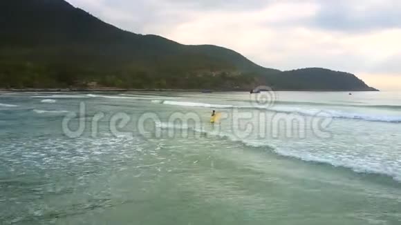 空中女孩在浅海上持冲浪板行走视频的预览图