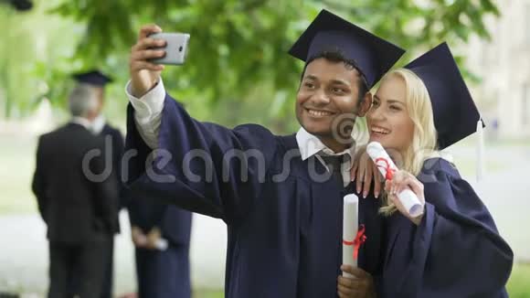 穿着毕业服装的年轻人用手机自拍视频的预览图