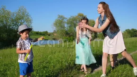 夏天在湖边的大自然中玩肥皂泡的快乐家庭视频的预览图