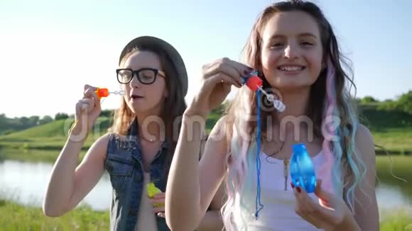在阳光明媚的夏日少女们在大自然中吹肥皂泡视频的预览图
