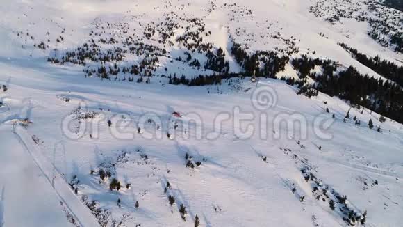 空中拍摄的神奇山脉有很多雪人们跑在雪车后面4K视频的预览图
