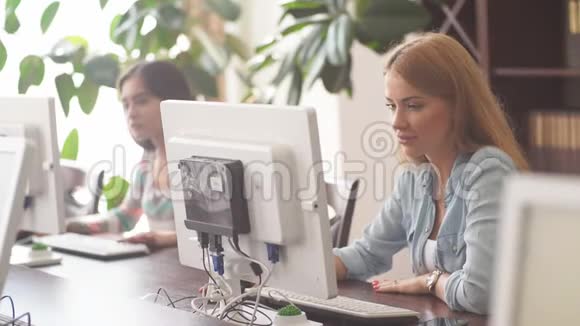 白人妇女使用个人电脑浏览办公室图书馆的网络视频的预览图