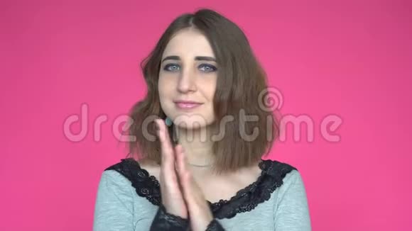 粉红色背景下为年轻女子鼓掌的快乐肖像视频的预览图