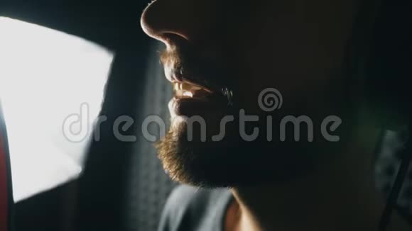 男歌手在录音室唱歌的嘴无法辨认的人录制新歌有胡子的人唱麦克风视频的预览图