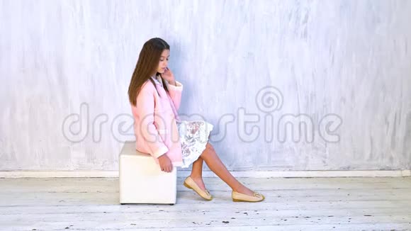 一个漂亮时尚的女孩在灰色背景上摆姿势视频的预览图