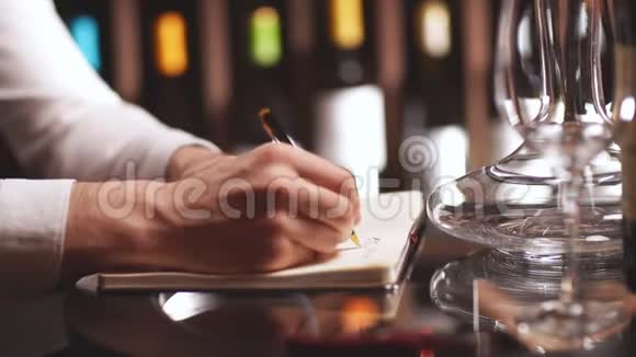 男酒管家看着酒瓶在酒肆的笔记本上写着视频的预览图
