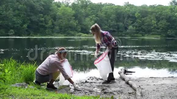 志愿者在河边清理垃圾女人在湖里捡起一瓶塑料环境污染视频的预览图