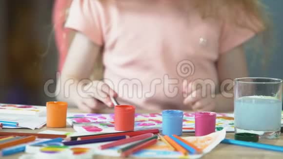 两个多种族的孩子在作坊里画水彩画创造力视频的预览图