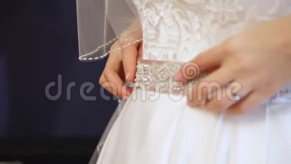 新娘费新娘为婚礼穿好衣服新娘手的特写用一个温和的美甲对着视频的预览图