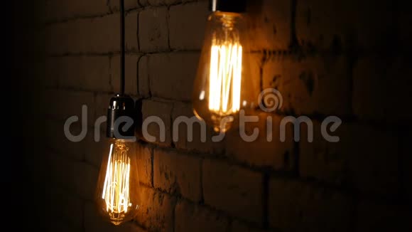 老式灯丝爱迪生灯泡灯在黑暗中亮起带有钨丝的白炽灯视频的预览图