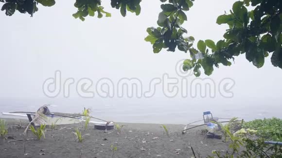 沙滩上的木船海上的雨和风暴雨水落在沙滩上渔船落在岸边视频的预览图