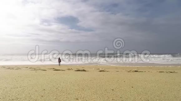 一个女人站在海边看着海浪视频的预览图