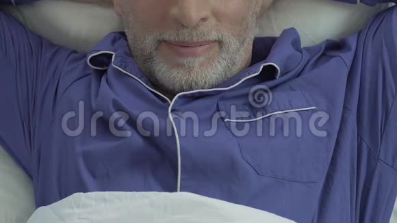 成年男性躺在床上伸展身体满意的男人醒来近距离观看视频的预览图