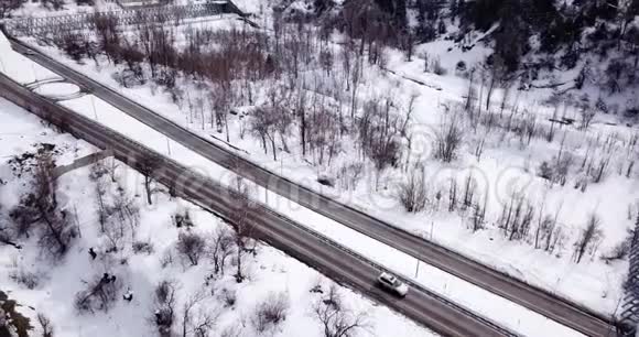 从一架无人机在山上的公路上射击路过的汽车公共汽车视频的预览图
