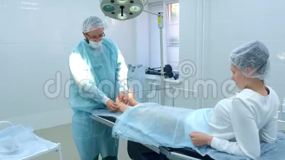 外科医生在手术前触诊腿部以去除关节中的脚踝湿瘤特写视频的预览图