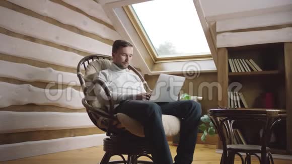 成人在椅子上用笔记本电脑上网视频的预览图