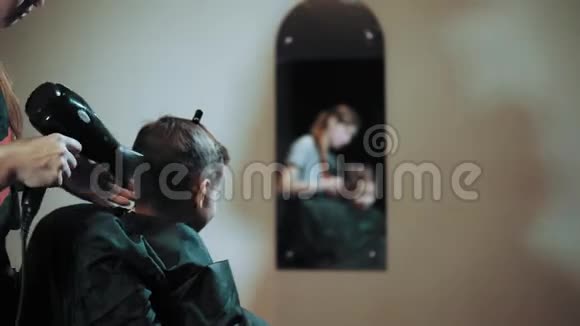 发型师在美发沙龙理发时给男孩理发视频的预览图