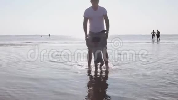 爸爸和他的小儿子在炎热的夏天在水上散步视频的预览图