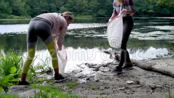 志愿者在河边清理垃圾女人在湖里捡起一瓶塑料环境污染视频的预览图