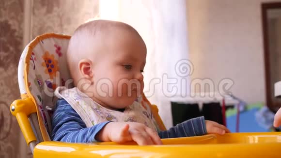 妈妈用勺子喂宝宝而小可爱的小男孩则在看着4K慢慢的妈妈视频的预览图