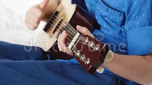 一个孩子的手拿着吉他一个小男孩弹吉他音乐教育教育视频的预览图