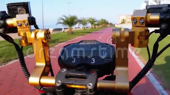 在度假小镇的红自行车道上骑电动自行车上面有棕榈树视频的预览图