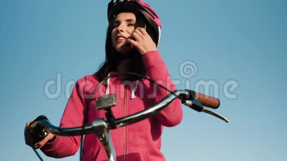 骑自行车的女孩穿着运动服戴着防蓝天的头盔视频的预览图