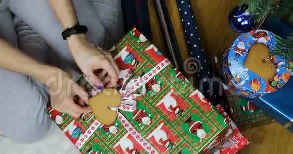 女孩把包装好的新年礼物放在节日树下视频的预览图