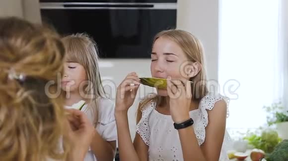 特写镜头可爱的白种人儿童穿着白色衣服吃新鲜的甜瓜有魅力的家庭在餐桌上吃甜瓜视频的预览图