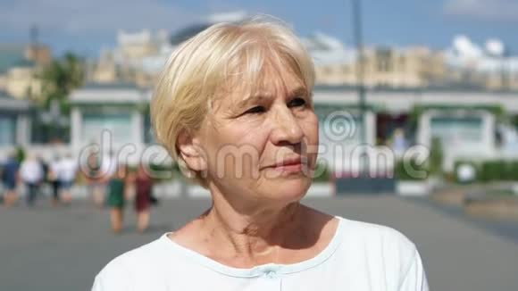 微笑的女人站在户外看镜头的肖像在俄罗斯莫斯科旅行的退休人员视频的预览图