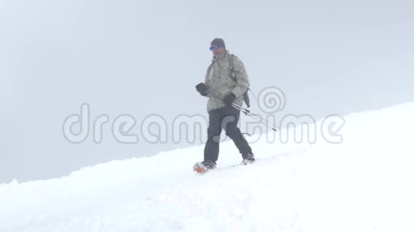 一个登山者沿着积雪覆盖的斜坡向下到达大本营埃尔布鲁斯山高加索山脉视频的预览图