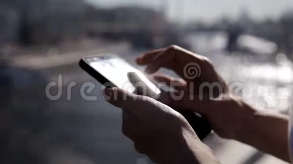 美丽的女孩戴着太阳镜长发在桥上日落时使用智能手机应用程序视频的预览图