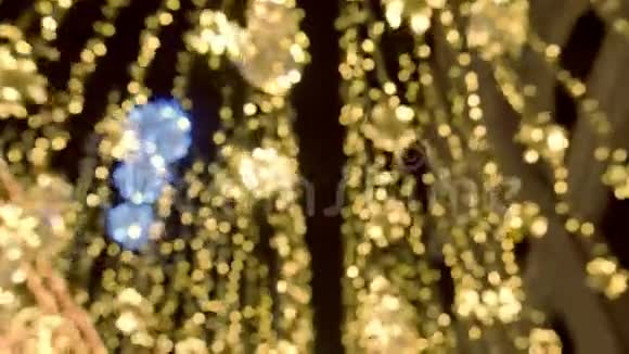 移动的金色圣诞灯美丽的闪烁装饰的街道模糊的背景视频的预览图