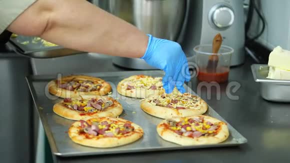 特写从酵母面团中烹饪几个迷你披萨的过程香肠和奶酪厨师洒披萨和视频的预览图