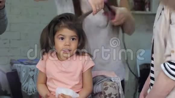 理发师在美容院为儿童做专业发型视频的预览图