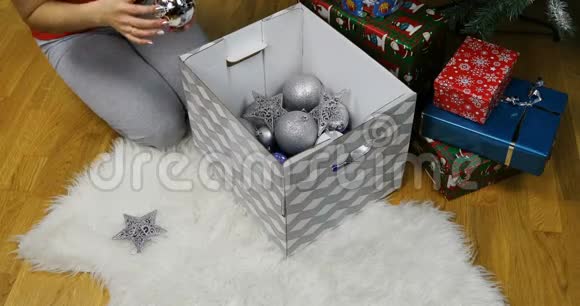 女人手把圣诞玩具放在毛皮地毯上视频的预览图