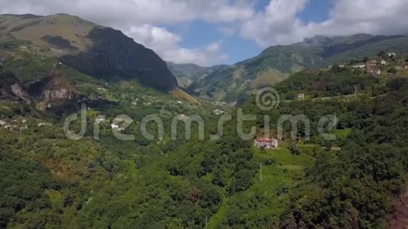鸟瞰山峡谷丘陵被绿色森林覆盖无人驾驶飞机飞越山地丘陵地带视频的预览图