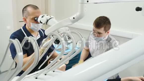 医生用显微镜现代牙科诊所的牙医治疗病人正畸医生与一名助手合作这就是视频的预览图