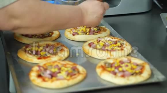 特写从酵母面团中烹饪几个迷你披萨的过程香肠和奶酪厨师洒披萨和视频的预览图