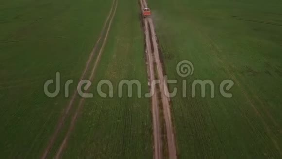 从空中俯瞰绿色的田野和一辆卡车在土路上行驶视频的预览图