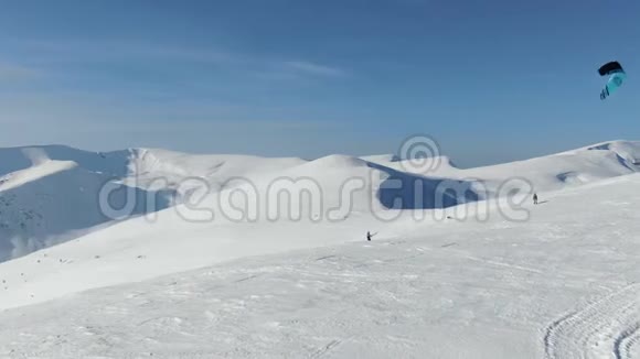 一个滑雪板上的人正在雪地上滑行背景很美视频的预览图