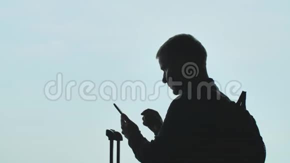 一个年轻人在飞机起飞的背景上打电话的剪影视频的预览图