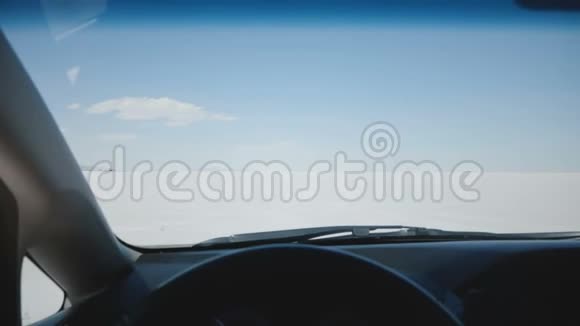 汽车方向盘后的POV摄像机沿着令人惊叹的白色盐湖沙漠平原向晴朗的天空地平线移动视频的预览图