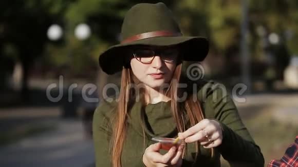 街上戴着绿帽子的普通女孩把薯条蘸上酱汁享受着吃的乐趣视频的预览图