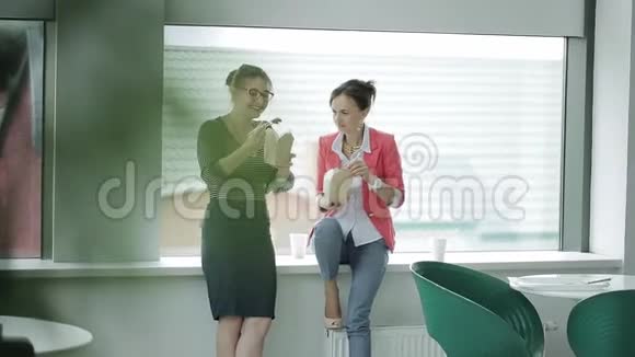 两个商务妇女在自助餐厅的窗口午休吃中国菜喝咖啡最后视频的预览图