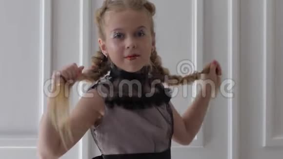 快乐的小女孩有着闪亮的妆容和发型在室内旋转视频的预览图