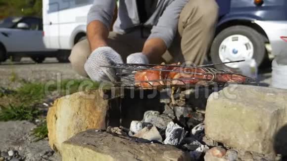 一个男人在户外的烤架上做肉背景是汽车旅馆视频的预览图